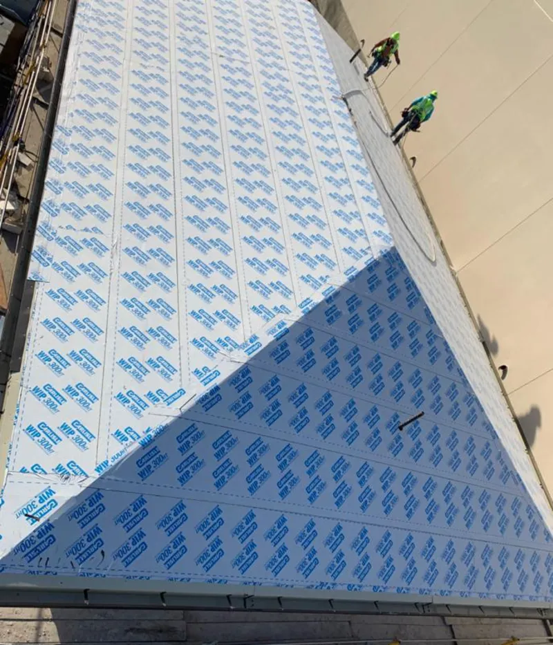 Professional roofers installing underlayment on a metal roof in Fredericksburg